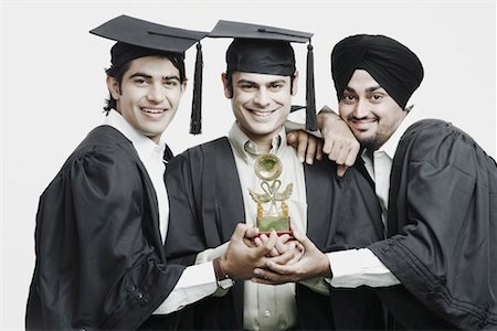 Portrait of three male graduates holding a trophy Stock Photo - Premium Royalty-Free, Code: 630-01077116