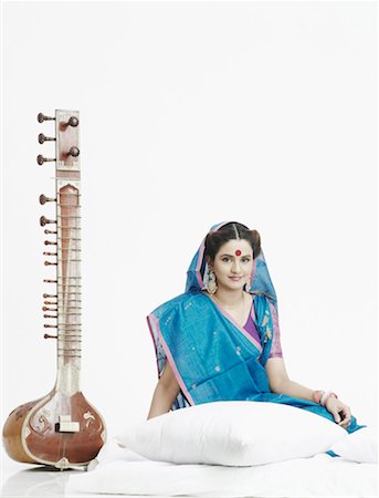 Portrait of a young woman sitting near a sitar Stock Photo - Premium Royalty-Free, Code: 630-01077196