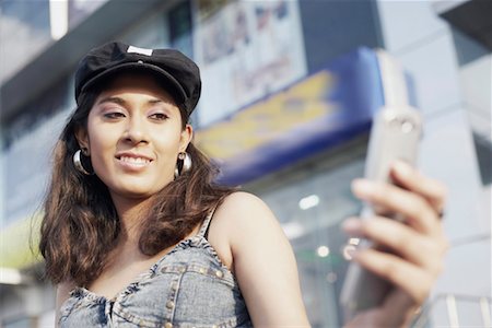 simsearch:630-01078755,k - Low angle view of a young woman holding a mobile phone Fotografie stock - Premium Royalty-Free, Codice: 630-01077724