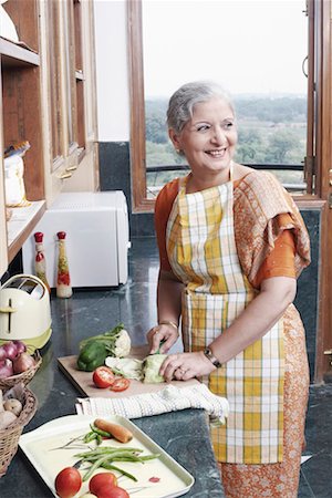 Mature woman cutting vegetables in the kitchen Foto de stock - Sin royalties Premium, Código: 630-01077824