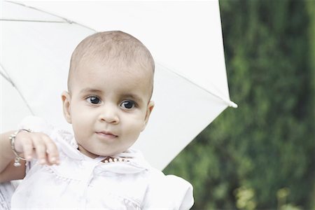 Close-up of a girl with an umbrella behind her Stock Photo - Premium Royalty-Free, Code: 630-01077937