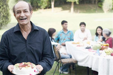 Portrait of a senior man holding a cake Stock Photo - Premium Royalty-Free, Code: 630-01077962