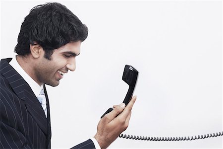 simsearch:630-01078367,k - Side profile of a businessman holding a telephone receiver Foto de stock - Sin royalties Premium, Código: 630-01078632