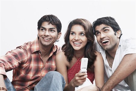 Close-up of a young woman and two young men smiling Stock Photo - Premium Royalty-Free, Code: 630-01078760