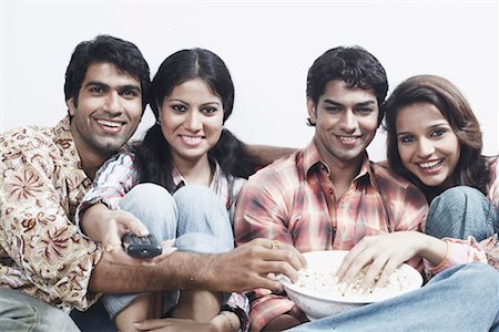 remote control, white background - Portrait of two young couples sitting together on a couch and eating popcorn Stock Photo - Premium Royalty-Free, Code: 630-01078771