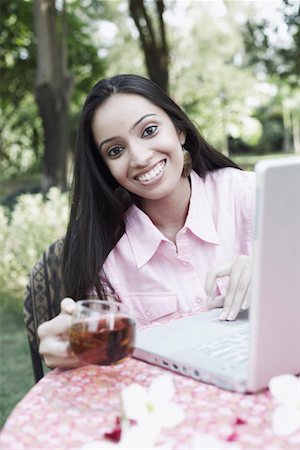 Portrait of a teenage girl sitting in front of a laptop Stock Photo - Premium Royalty-Free, Code: 630-01079043