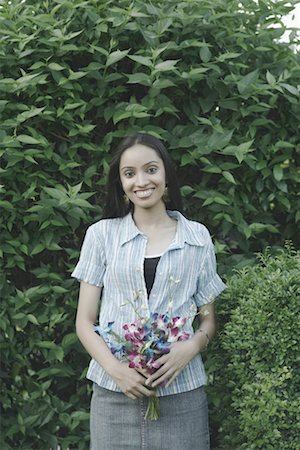 Portrait of a teenage girl holding a bunch of flowers Stock Photo - Premium Royalty-Free, Code: 630-01079133