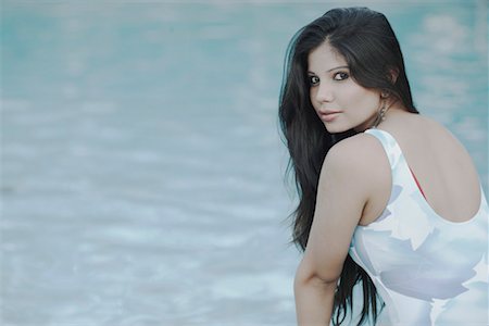 Portrait of a young woman sitting at the poolside Stock Photo - Premium Royalty-Free, Code: 630-01079155