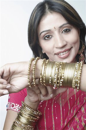 Portrait of a mid adult woman showing her bangles Stock Photo - Premium Royalty-Free, Code: 630-01079491