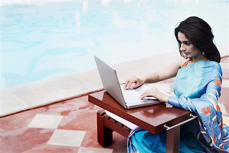 High angle view of a young woman using a laptop Stock Photo - Premium Royalty-Free, Code: 630-01079794