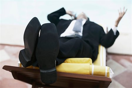 sole of shoe - Close-up of a businessman lying on a lounge chair talking on a mobile phone Stock Photo - Premium Royalty-Free, Code: 630-01079797