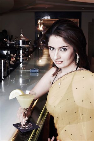 Portrait of a businesswoman at a bar counter holding a martini glass Stock Photo - Premium Royalty-Free, Code: 630-01080022