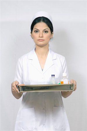 portrait medical white background not animal not smiling - Portrait of a female nurse holding a tray Stock Photo - Premium Royalty-Free, Code: 630-01080067