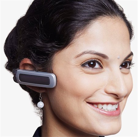 Close-up of a businesswoman wearing a hands free device and smiling Stock Photo - Premium Royalty-Free, Code: 630-01126737