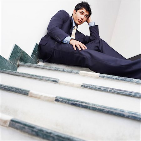 simsearch:630-02219583,k - Low angle view of a businessman sitting on the staircase Stock Photo - Premium Royalty-Free, Code: 630-01126773