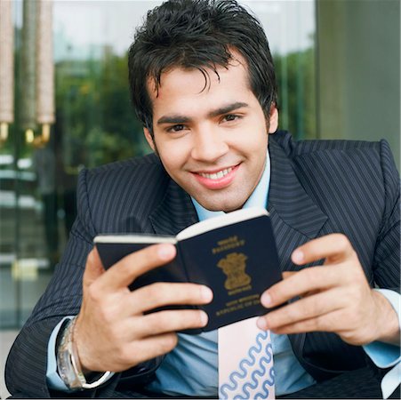 simsearch:630-01126991,k - Portrait of a businessman holding a passport and smiling Stock Photo - Premium Royalty-Free, Code: 630-01126986