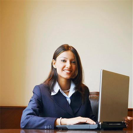 simsearch:630-01128810,k - Portrait of a businesswoman using a laptop and smiling Stock Photo - Premium Royalty-Free, Code: 630-01126987