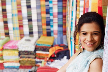 Portrait of a young woman smiling in a clothing store Stock Photo - Premium Royalty-Free, Code: 630-01127425