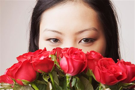 face with rose - Portrait of a young woman holding a bouquet of roses Stock Photo - Premium Royalty-Free, Code: 630-01127500