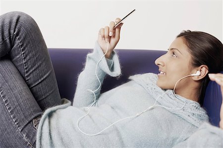 Close-up of a young woman listening to music Stock Photo - Premium Royalty-Free, Code: 630-01127613