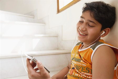 pictures of pre teen boys in tank tops - Close-up of a boy sitting on steps and listening to an MP3 player Foto de stock - Sin royalties Premium, Código: 630-01127668