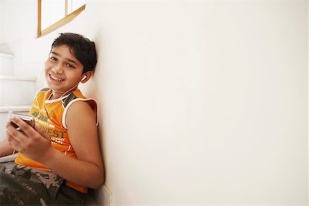 pictures of pre teen boys in tank tops - Portrait of a boy sitting on steps and listening to an MP3 player Stock Photo - Premium Royalty-Free, Code: 630-01127669