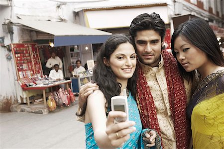 saree hug images - Close-up of a young man and two young women taking a photograph of themselves Stock Photo - Premium Royalty-Free, Code: 630-01127711