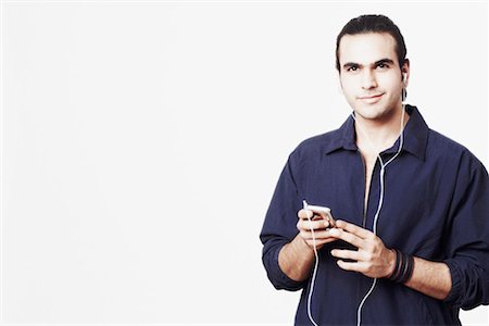 simsearch:630-01131178,k - Portrait d'un jeune homme à l'écoute d'un lecteur MP3 Photographie de stock - Premium Libres de Droits, Code: 630-01127721