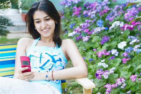 simsearch:630-01131411,k - Young woman holding a mobile phone and smiling Stock Photo - Premium Royalty-Free, Code: 630-01127805