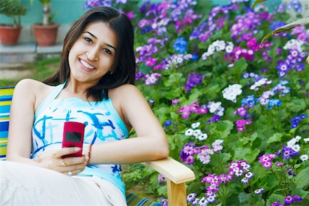 simsearch:630-01078178,k - Portrait d'une jeune femme tenant un téléphone mobile Photographie de stock - Premium Libres de Droits, Code: 630-01128053
