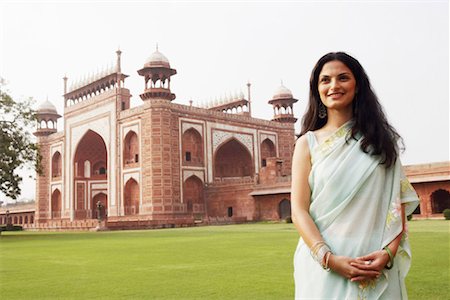 Portrait of a young woman standing in front of a mausoleum, Taj Mahal, Agra, Uttar Pradesh, India Stock Photo - Premium Royalty-Free, Code: 630-01128324