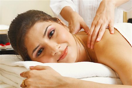 simsearch:630-01131387,k - Portrait of a young woman getting a shoulder massage from a massage therapist Fotografie stock - Premium Royalty-Free, Codice: 630-01128535