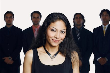 simsearch:630-01128784,k - Portrait of a young woman smiling with four businessmen standing behind her Stock Photo - Premium Royalty-Free, Code: 630-01128630