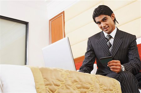 simsearch:630-01128811,k - Portrait of a Businessman holding eine Kreditkarte und sitzt vor einem laptop Stockbilder - Premium RF Lizenzfrei, Bildnummer: 630-01128653