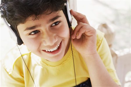 High angle view of a boy listening to music on headphones Stock Photo - Premium Royalty-Free, Code: 630-01128690