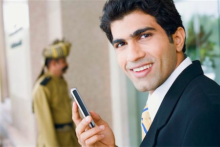 simsearch:630-01131198,k - Portrait of a Businessman holding ein Mobiltelefon und Lächeln Stockbilder - Premium RF Lizenzfrei, Bildnummer: 630-01128756