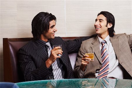 Close-up of two businessmen holding glasses of whiskey Stock Photo - Premium Royalty-Free, Code: 630-01128777