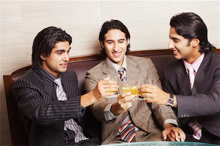 Close-up of three businessmen toasting with glasses of whiskey Stock Photo - Premium Royalty-Free, Code: 630-01128779