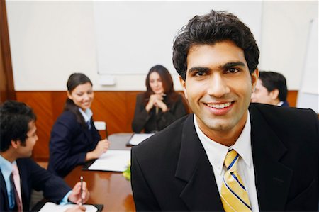 simsearch:630-01128982,k - Portrait of a businessman with his colleagues sitting behind him Stock Photo - Premium Royalty-Free, Code: 630-01128847