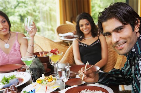 simsearch:630-01130529,k - Two young women and a young man dining in a restaurant Stock Photo - Premium Royalty-Free, Code: 630-01128929