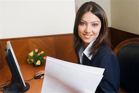 simsearch:630-01130741,k - Portrait of a businesswoman working on a computer and holding a sheet of paper Stock Photo - Premium Royalty-Free, Code: 630-01128989