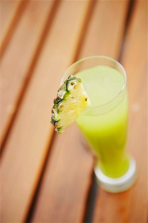 High angle view of a glass of pineapple juice on a bench Stock Photo - Premium Royalty-Free, Code: 630-01129104