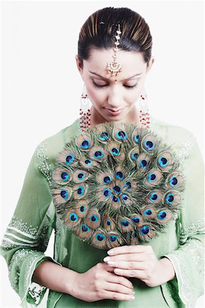 Close-up of a young woman holding a peacock feather fan Foto de stock - Sin royalties Premium, Código: 630-01129405