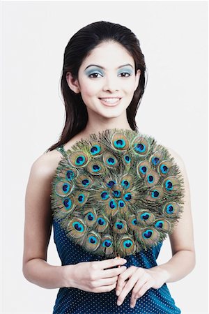 Portrait d'une jeune femme tenant un ventilateur pliable et souriant Photographie de stock - Premium Libres de Droits, Code: 630-01129773