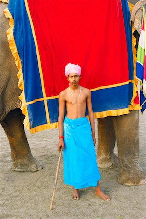 Close-up of a young man standing near an elephant Stock Photo - Premium Royalty-Free, Code: 630-01130018