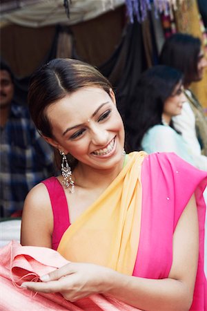 Close-up of a young woman smiling in a clothing store Stock Photo - Premium Royalty-Free, Code: 630-01130034