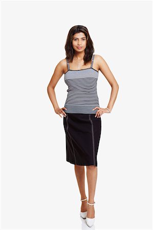 stripe skirt woman - Portrait of a young woman standing with arms akimbo Stock Photo - Premium Royalty-Free, Code: 630-01130174
