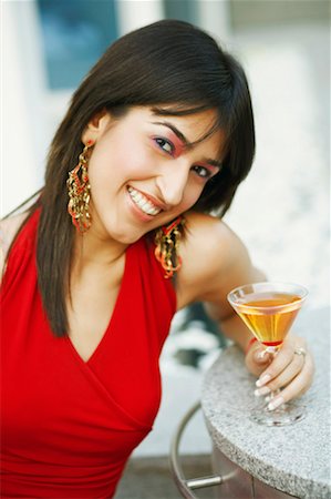 simsearch:630-01128103,k - Portrait of a young woman holding a glass of cocktail and smiling Stock Photo - Premium Royalty-Free, Code: 630-01130173