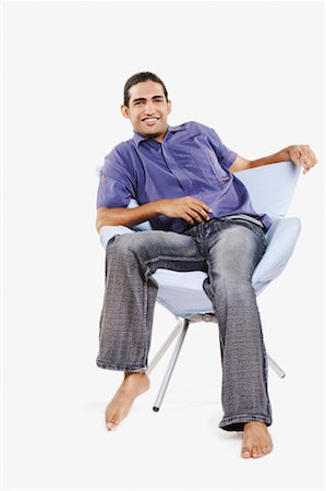 simsearch:630-01131178,k - Portrait d'un jeune homme assis sur une chaise et souriant Photographie de stock - Premium Libres de Droits, Code: 630-01130193