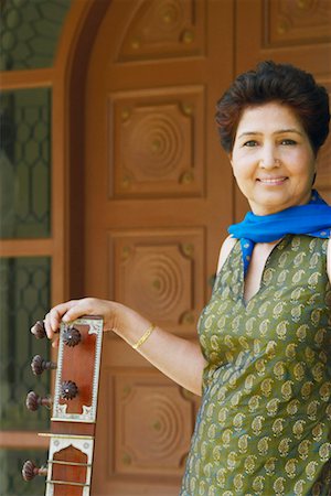 simsearch:630-01131008,k - Portrait of a mature woman holding a sitar and smiling Foto de stock - Sin royalties Premium, Código: 630-01130747